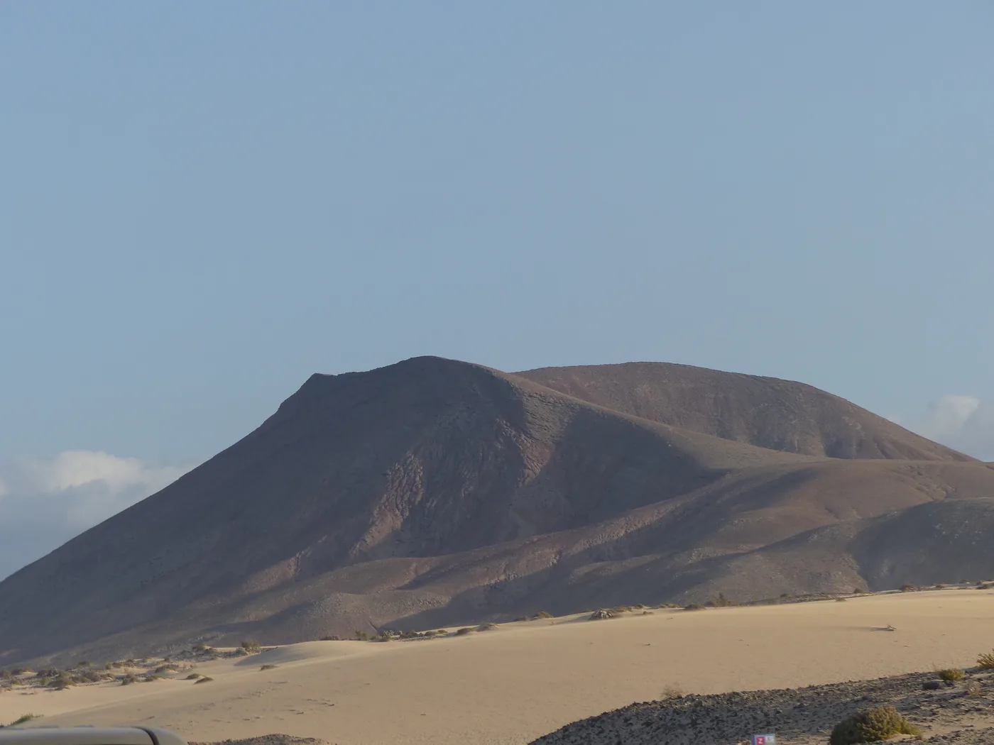 A dune of Corralejo with a volcanic mountain behind it