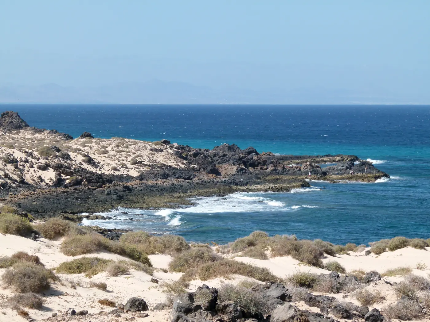 Corralejo dunes and dark volcanic shore looking across the Atlantic, Fuerteventura.