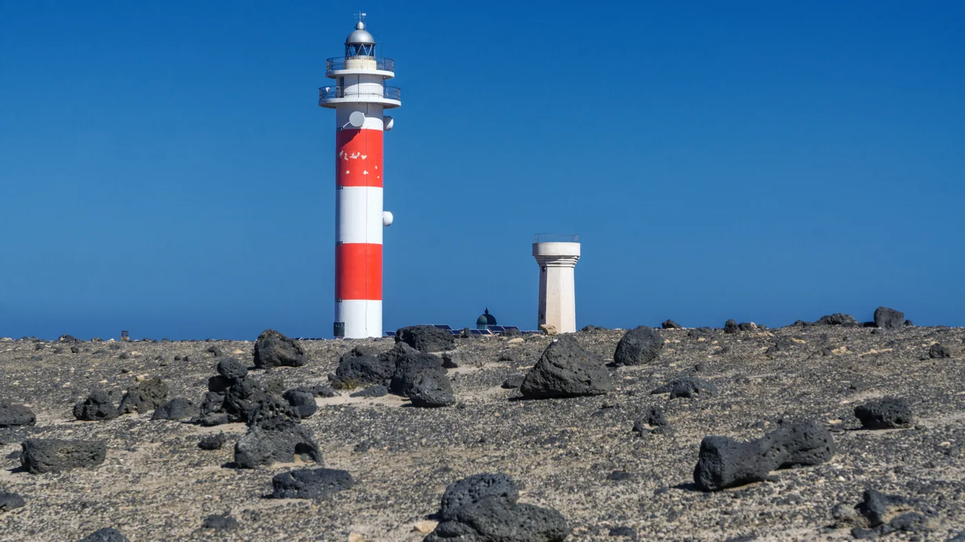 The Tostón lighthouse at El Cotillo, its towers against the sea