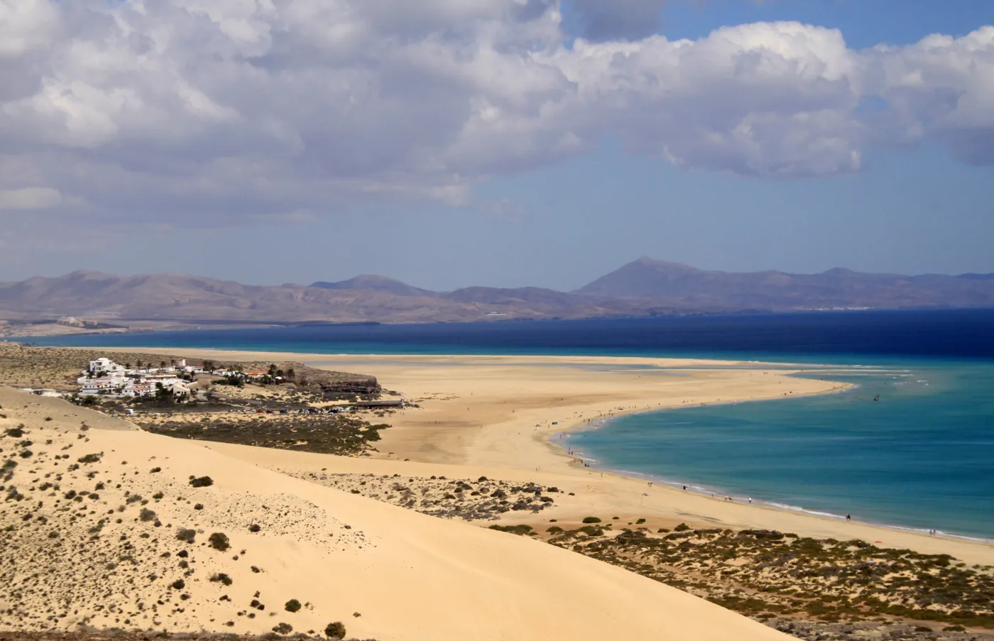 The pale sand beach of Mal Nombre with turquoise sea and mountains behind, Fuerteventura.