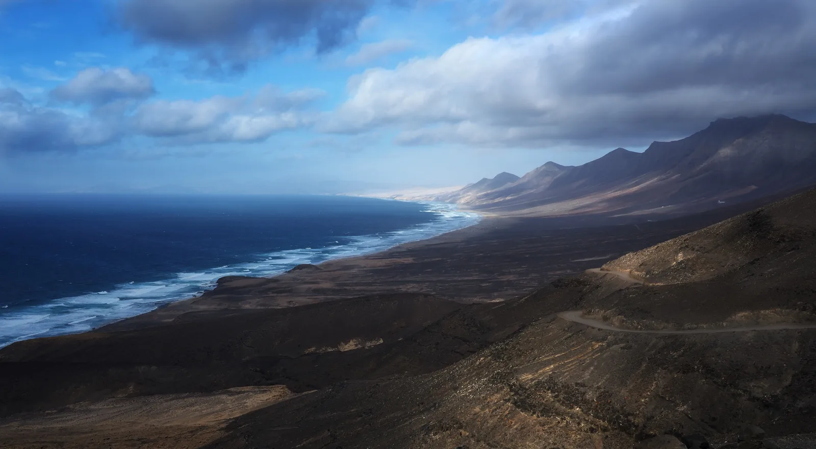 Cofete beach sweeping beneath the Jandía mountains on Fuerteventura's wild west coast.